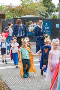 Pre-school children walking with Secondary School students across campus.